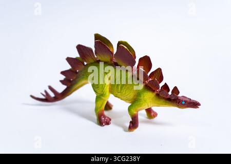 Lo stegosauro di plastica si stegosaurus su uno sfondo bianco, evocando l'infanzia e il gioco fantasioso Foto Stock