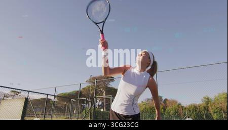 Racchetta in mano, tennista con la maglia bianca, gonna nera che prepara il servizio al campo da tennis con la rete Foto Stock