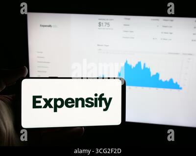 In questa immagine, una persona ha in mano uno smartphone con il logo della società di gestione delle spese Expensify Inc. Sullo schermo davanti al sito Web. (Foto di Timon Schneider / SOPA Images/Sipa USA) *** esclusivamente per notizie editoriali *** Foto Stock