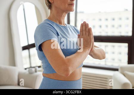 Donna caucasica adulta che pratica Yoga Meditazione al chiuso con Focus Foto Stock