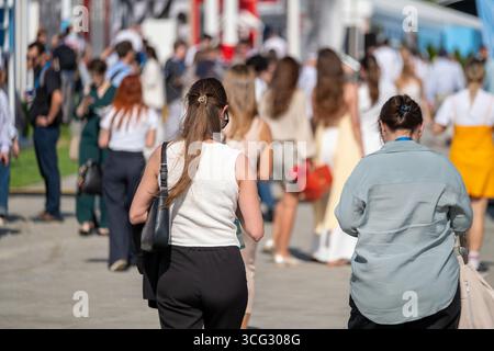 Scena che raffigura una folla che partecipa a un evento all'aperto in una giornata calda, mostrando un'attività vivace. Foto Stock