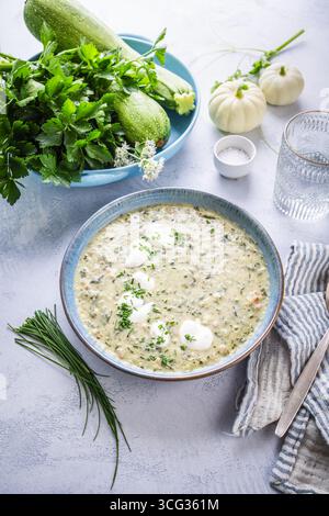 Zuppa estiva fredda di zucchine e yogurt con erba cipollina sul tavolo da cucina, gazpacho di zucchine Foto Stock