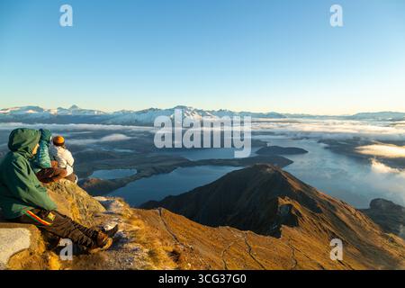 Gli escursionisti ammirano una splendida alba sul Roy's Peak e si affacciano sul lago Wanaka verso il Mount Aspiring National Park Foto Stock