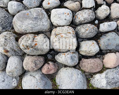 Una serie di pietre varie, arrotondate e strutturate. Foto Stock