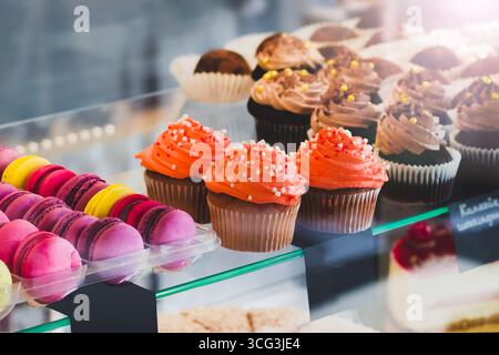 Mostra dolci al caffè. Cupcake e macaron colorati sul display per torte Foto Stock