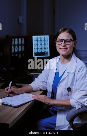Ritratto di giovane donna caucasica adulta Dottore scrittura rapporto medico Foto Stock