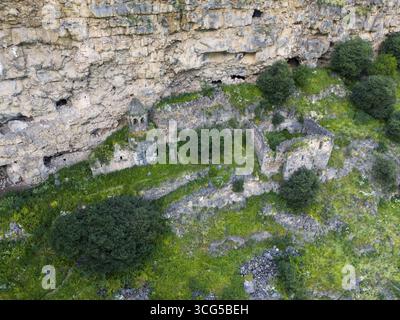 Antiche rovine tra vegetazione verde su una parete rocciosa, vista aerea, monastero di Horomayr, Odsun, Odzun, gola di Debed, provincia di Lorikeet, Armenia Foto Stock