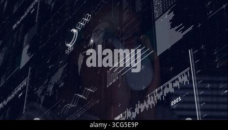 Donna che indossa un visore VR che naviga nella visualizzazione AR in uno studio buio, con mappa del mondo e mappe dei dati Foto Stock