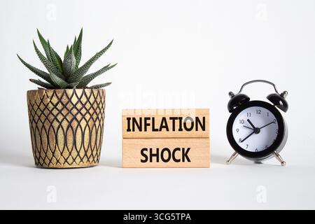 Simbolo della scarica di gonfiaggio. Parola concettuale gonfiaggio shock su blocchi di legno. Splendido sfondo bianco con sveglia e piante succulente. Io e gli affari Foto Stock