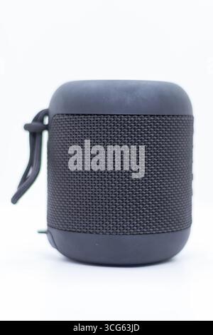 Immagine ad alta risoluzione di un altoparlante Bluetooth portatile nero con copertura in tessuto, isolata su uno sfondo bianco. Perfetto per la tecnologia audio, Foto Stock