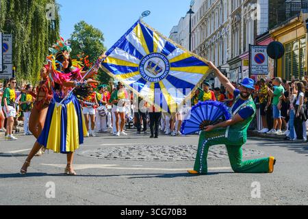 Il Carnevale di Notting Hill prende il via mentre i partecipanti alla sfilata in abiti colorati e suggestivi intratterranno quelli fiancheggiati lungo il percorso. Foto Stock