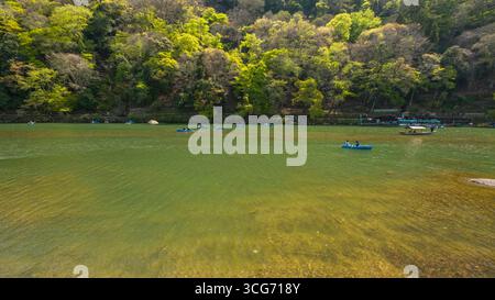 Barche a remi turistiche sul fiume Katsura in una giornata di sole ad aprile, Arashiyama, Ukyo Ward, Kyoto, Kansai, Honshu, Giappone Foto Stock