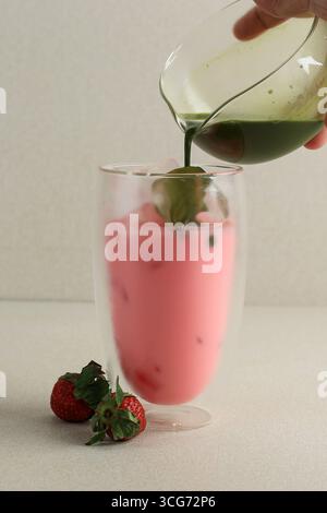 Versare Greentea Matcha al bicchiere con latte di fragola, passo dopo passo preparare la fragola Matcha Foto Stock