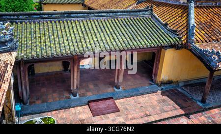 Vista della cittadella proibita sopra e delle antiche case con tetti in piastrelle a Hue, Vietnam Foto Stock