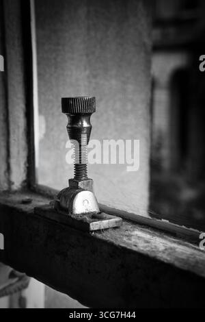 Chiusura finestra vintage in bianco e nero. Primo piano di un vecchio dispositivo di fissaggio in metallo. Foto Stock