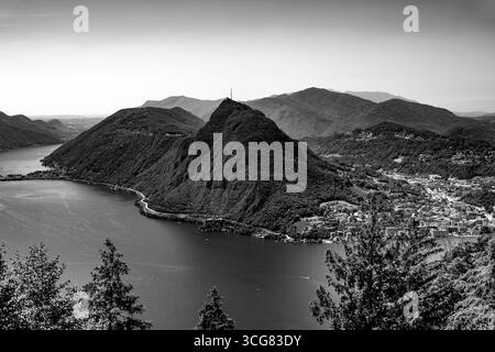 Vista panoramica sul lago di Lugano e sulle montagne e sulla città in una giornata estiva di sole a Lugano, Ticino, Svizzera. Foto Stock