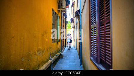 Il quartiere vecchio della città, le ragazze sono fotografate nelle strette strade di Hoi An Foto Stock