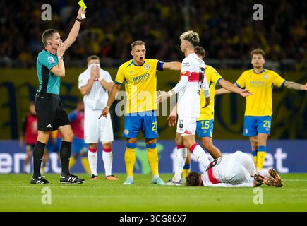 26 agosto 2025, Braunschweig, bassa Sassonia, Germania: L'arbitro FLORIAN EXNER mostra un cartellino giallo al centrocampista di Eintracht Braunschweig SVEN KOHLER (27) come centrocampista della VfB Stuttgart ATAKAN KARAZOR (16) e Eintracht Braunschweig difensore KEVIN EHLERS (21) e VfB Stuttgart attaccante TIAGO TOMAS (8) è 2025 in basso nel primo turno di Stoccarda Braunschweig 26 agosto a Stoccarda Braunschweig a Stoccarda Braunschweig a Stoccarda, Germania. Il match finì 4-4 dopo i tempi supplementari prima che Stoccarda vinsero 8-7 ai rigori. (Credit Image: © Scott Coleman/ZUMA Press Wire) SOLO PER USO EDITORIALE! Foto Stock