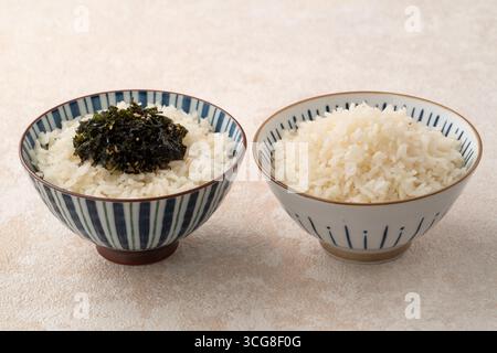 Una ciotola di soffice riso bianco condita con condimenti di riso. Foto Stock