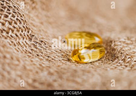 Due capsule di olio di pesce giallo. Omega complesso vitaminico 3,6,9. Copia spazio Foto Stock
