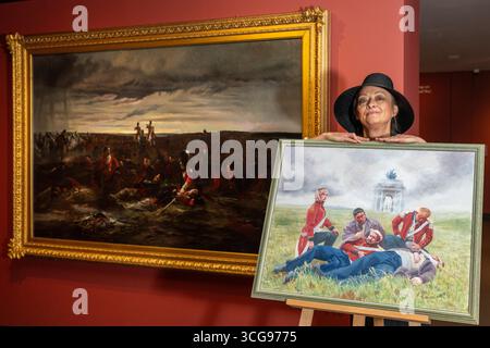 Londra, Regno Unito. 27 agosto 2025. Artista Alexandra Veres con il suo lavoro «Dusk of Waterloo», 2025, la sua reinterpretazione di (L) «The Dawn of Waterloo. La "Reveille" nel bivacco dei grigi scozzesi la mattina della battaglia, 1815, 1895, di Lady Butler. Photocall presso il National Army Museum, che ha commissionato ad artisti contemporanei di reinterpretare iconici dipinti militari vittoriani nella sua mostra "Myth and Reality: Military Art in the Age of Queen Victoria", che si svolge fino al 1° novembre. Crediti: Stephen Chung / Alamy Live News Foto Stock
