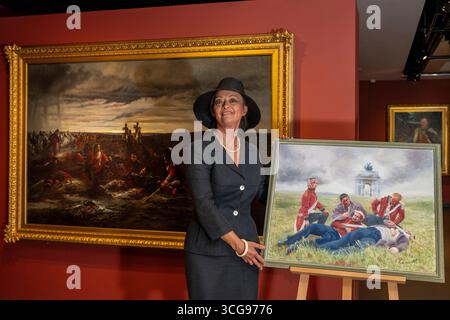 Londra, Regno Unito. 27 agosto 2025. Artista Alexandra Veres con il suo lavoro «Dusk of Waterloo», 2025, la sua reinterpretazione di (L) «The Dawn of Waterloo. La "Reveille" nel bivacco dei grigi scozzesi la mattina della battaglia, 1815, 1895, di Lady Butler. Photocall presso il National Army Museum, che ha commissionato ad artisti contemporanei di reinterpretare iconici dipinti militari vittoriani nella sua mostra "Myth and Reality: Military Art in the Age of Queen Victoria", che si svolge fino al 1° novembre. Crediti: Stephen Chung / Alamy Live News Foto Stock