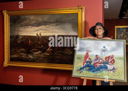Londra, Regno Unito. 27 agosto 2025. Artista Alexandra Veres con il suo lavoro «Dusk of Waterloo», 2025, la sua reinterpretazione di (L) «The Dawn of Waterloo. La "Reveille" nel bivacco dei grigi scozzesi la mattina della battaglia, 1815, 1895, di Lady Butler. Photocall presso il National Army Museum, che ha commissionato ad artisti contemporanei di reinterpretare iconici dipinti militari vittoriani nella sua mostra "Myth and Reality: Military Art in the Age of Queen Victoria", che si svolge fino al 1° novembre. Crediti: Stephen Chung / Alamy Live News Foto Stock