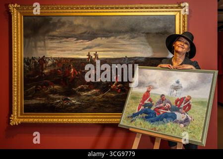 Londra, Regno Unito. 27 agosto 2025. Artista Alexandra Veres con il suo lavoro «Dusk of Waterloo», 2025, la sua reinterpretazione di (L) «The Dawn of Waterloo. La "Reveille" nel bivacco dei grigi scozzesi la mattina della battaglia, 1815, 1895, di Lady Butler. Photocall presso il National Army Museum, che ha commissionato ad artisti contemporanei di reinterpretare iconici dipinti militari vittoriani nella sua mostra "Myth and Reality: Military Art in the Age of Queen Victoria", che si svolge fino al 1° novembre. Crediti: Stephen Chung / Alamy Live News Foto Stock