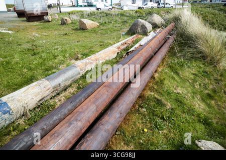 vecchi e nuovi pali telegrafici conservati vicino al porto dell'isola di tory, contea di donegal, repubblica d'irlanda Foto Stock