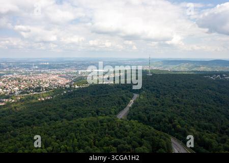 Vista panoramica del paesaggio urbano di Stoccarda e delle verdi colline circostanti, con una strada che si snoda attraverso la lussureggiante foresta verso la TV di Stoccarda Foto Stock