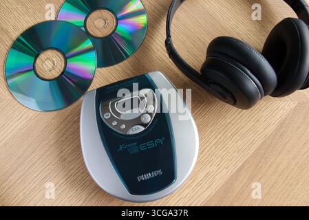 Philips Discman accanto alle cuffie e ai CD musicali su uno sfondo in legno Foto Stock