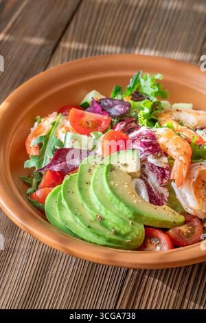 Vivace insalata di gamberi avocado verdure fresche condimento agrumi tavolo in legno rustico Foto Stock