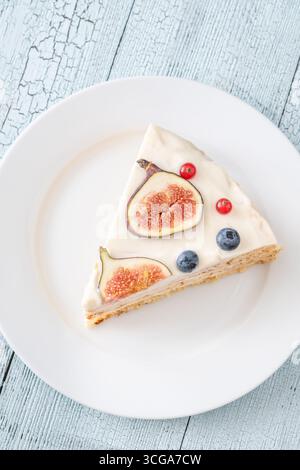 Torta al formaggio spalmabile con spicchi di fichi ribes mirtilli servita con piatto bianco Foto Stock