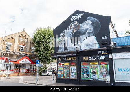 Grande immagine di graffiti raffigurante il calciatore Lionel messi con la Coppa del mondo. La CAPRA, il più grande slogan di tutti i tempi. Negozio di carte sportive On Card Galacticos Foto Stock