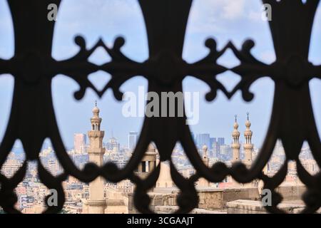 Paesaggio urbano del Cairo incorniciato da tradizionali tralicci islamici Foto Stock