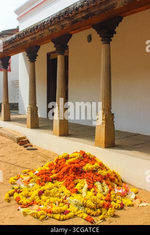 Case tradizionali dell'India meridionale con tetti spioventi, colonne di legno, cortili e vivaci dettagli culturali, che riflettono l'architettura e il patrimonio regionale. Foto Stock