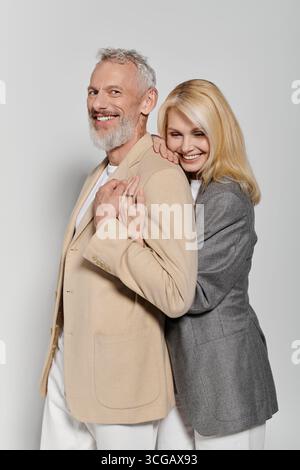 Una coppia amorevole si abbraccia a vicenda, indossando abiti alla moda, irradiando gioia e calore. Foto Stock