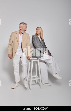 La coppia senior vestita elegantemente condivide una risata, mostrando il loro amore e la loro connessione. Foto Stock