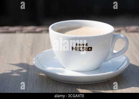 REGNO UNITO. Uno shot ravvicinato di un caffè fresco in una tazza Caffe Nero di marca. Il marchio della casa di caffè indipendente è chiaramente visibile sulla tazza Foto Stock