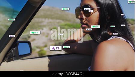 Guarda la donna indiana che indossa occhiali da sole aviatore in cabriolet su strada rurale, copia spazio Foto Stock