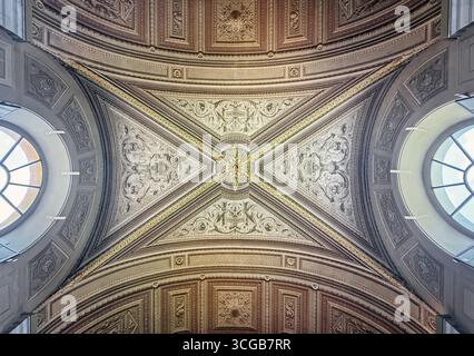Una splendida vista di un soffitto decorato con gusto, caratterizzato da un design grandioso e simmetrico. Intricate incisioni, dettagli dorati e dettagli in rilievo all'interno Foto Stock