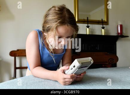 Bambino che gioca con un Nintendo Gameboy vintage anni '1980 Foto Stock