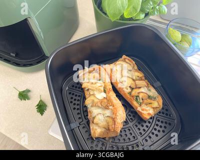 Bruschetta con funghi porcini e formaggio. Cibo e prodotti di qualità cotti nella friggitrice aerodinamica. Cucina tradizionale italiana. Foto Stock