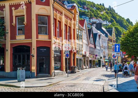 BERGEN, NORVEGIA - 17 AGOSTO 2025: I tradizionali edifici nordici colorati fiancheggiano una strada acciottolata a Bergen, Norvegia. Bergen è una città nel sud della Norvegia Foto Stock