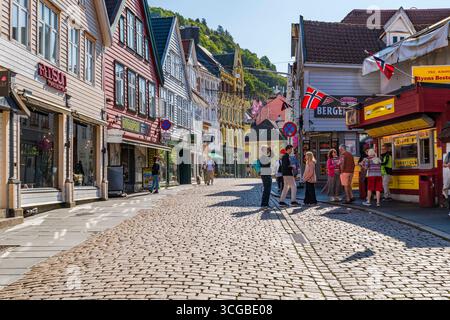 BERGEN, NORVEGIA - 17 AGOSTO 2025: I tradizionali edifici nordici colorati fiancheggiano una strada acciottolata a Bergen, Norvegia. Bergen è una città nel sud della Norvegia Foto Stock