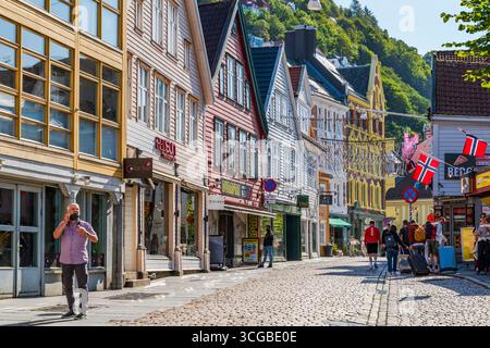 BERGEN, NORVEGIA - 17 AGOSTO 2025: I tradizionali edifici nordici colorati fiancheggiano una strada acciottolata a Bergen, Norvegia. Bergen è una città nel sud della Norvegia Foto Stock