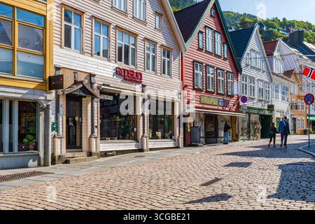 BERGEN, NORVEGIA - 17 AGOSTO 2025: I tradizionali edifici nordici colorati fiancheggiano una strada acciottolata a Bergen, Norvegia. Bergen è una città nel sud della Norvegia Foto Stock