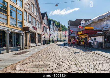 BERGEN, NORVEGIA - 17 AGOSTO 2025: I tradizionali edifici nordici colorati fiancheggiano una strada acciottolata a Bergen, Norvegia. Bergen è una città nel sud della Norvegia Foto Stock