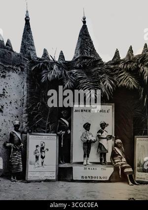 Fotografia tratta da l’Illustration, giugno 1916, che mostra la “Journée du Pullu” a Bondoukou, Côte d’Avorio. I bambini sono accanto ai manifesti in un evento culturale che promuove la fedeltà alla Francia durante la prima guerra mondiale. L'immagine illustra gli sforzi della propaganda coloniale per rafforzare i legami con le comunità musulmane dell'Africa occidentale. Tali incontri riflettevano il ruolo strategico dell'Africa occidentale francese nel fornire risorse e reclute allo sforzo bellico alleato. Foto Stock