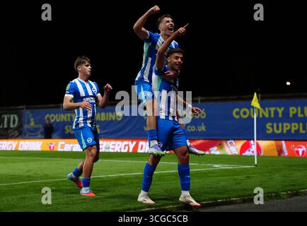 Stefanos Tzimas di Brighton e Hove Albion (a destra) festeggia con Harry Howell di Brighton e Hove Albion (a sinistra) e Brajan Gruda di Brighton e Hove Albion (al centro) dopo aver segnato il quarto gol ai suoi lati durante la partita del secondo turno della Carabao Cup all'Hill Kassam Stadium di Oxford. Data foto: Mercoledì 27 agosto 2025. Foto Stock